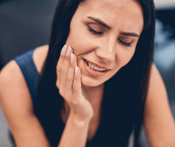 Person experiencing jaw pain from bruxism and TMD